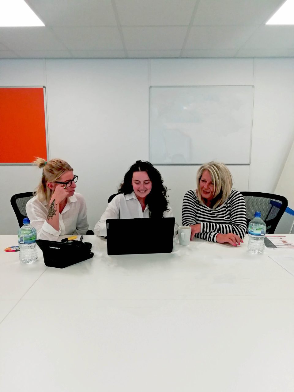 image of three women looking at the laptop
