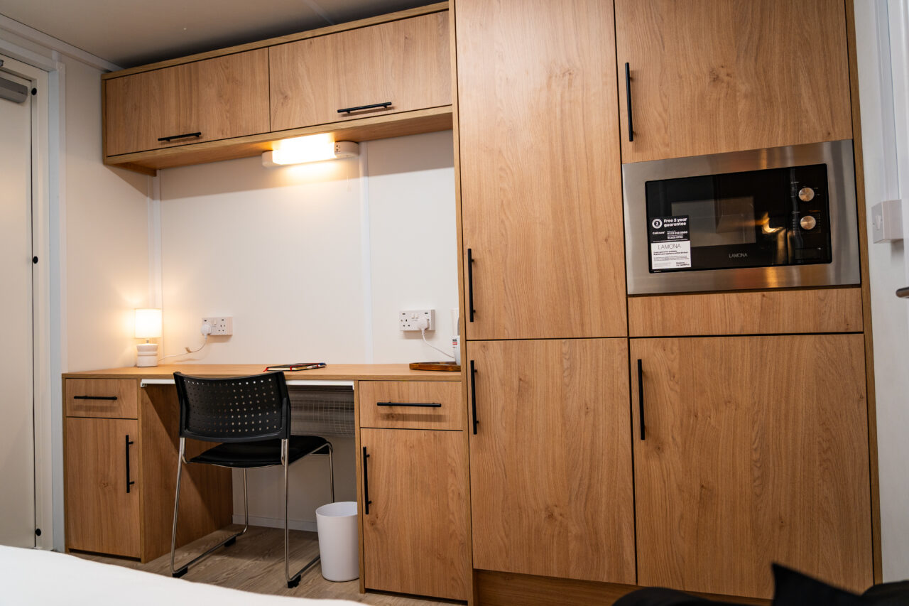 Mid view of the desk, cupboards, and microwave in the Wernick AVDanzer sleeping accommodation
