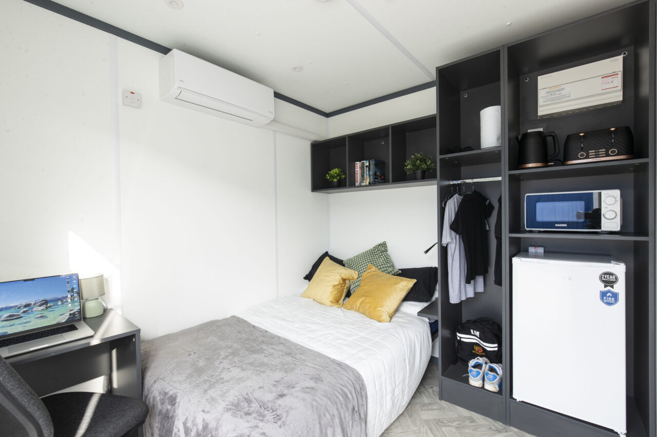 Interior image of the RestPod twinluxe cabin with a bed and shelving