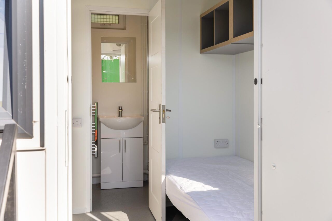 Internal image of a RestPod cabin with mattress and sink facility
